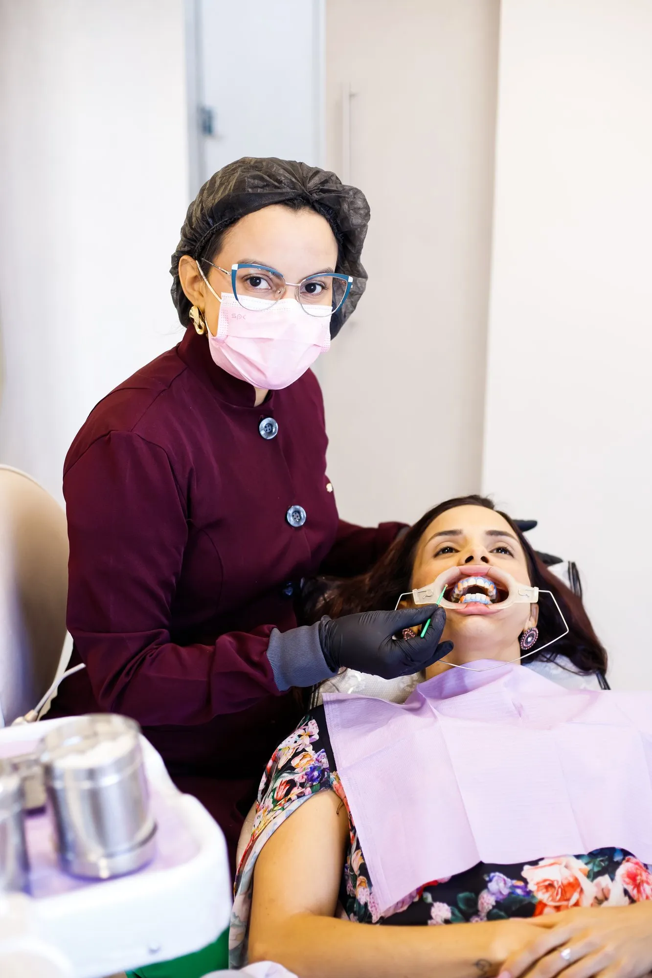 Dra. Ellane Talita atendendo uma paciente sorridente na cadeira
